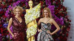Schauspielerin Katja Riemann mit floraler Haarspange und Tochter vor der Blumenwand