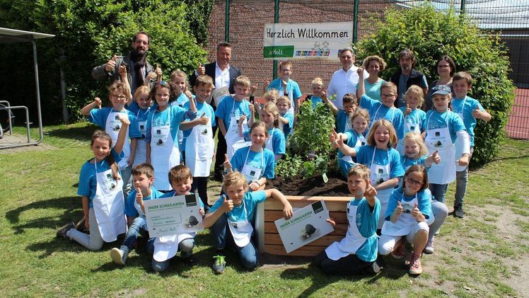 Personen im Bild hinten v.l.: Gemeinsam mit den Mädchen und Jungen der Katharinenschule Straelen, Teilstandort Auwel-Holt eröffneten Mark Ledwig (Vater/Mitglied im Förderverein), Armin Rehberg (Vorstandsvorsitzender der Landgard eG), Thomas Auler (Rektor Katharinenschule Straelen﻿), Anja Laube (Mutter/Mitglied im Förderverein), Matthias Peun (Hausmeister am Standort Auwel-Holt) und Anke Brüx (Mutter/Mitglied im Förderverein) am Montag, dem 27. Mai 2019, den neuen Schulgarten im Rahmen des Projekts „Unser Schulgarten“ der Landgard Stiftung. Bild: © Landgard Stiftung.