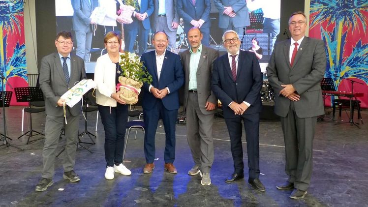 Der „Staffelstab“ in Form einer Fahne ist nun an die IGA Metropole Ruhr 2027 übergeben. Von links: Horst Fischer (Geschäftsführer der IGA27 gGmbH), Karola Geiß-Netthöfel (Regionaldirektorin des Regionalverbandes Ruhr), Christian Specht (Oberbürgermeister Mannheim), Michael Schnellbach (Geschäftsführer der BUGA23 gGmbH), Jochen Sandner (Geschäftsführer DBG) und Hajo Hinrichs (Vorsitzender der Gesellschafterversammlung der DBG). Bild: DBG.