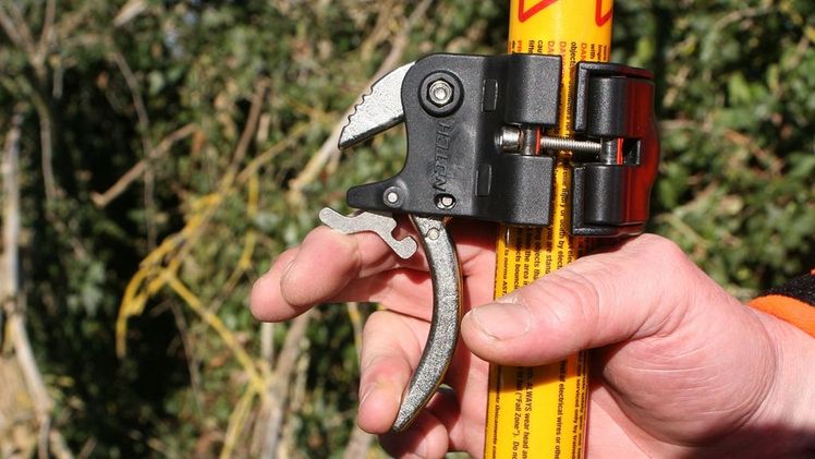 Sicherung des Auslösers. Durch aktives nach oben drücken wird der Auslöser freigegeben. Bild: SVLFG.