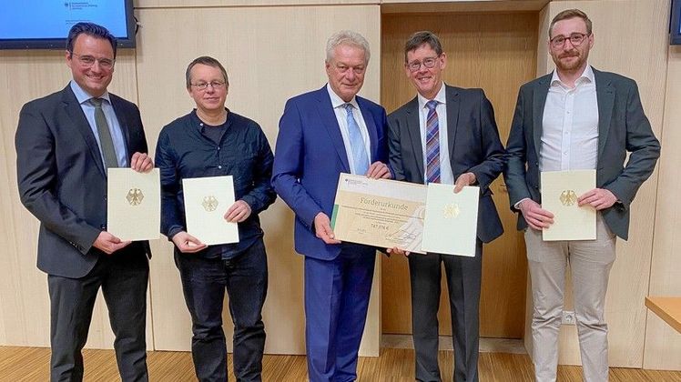 Aus den Händen von Minister Rainer (Mitte) erhielt das Projektteam vertreten von Prof. Paul Lampert (FHE), Dr. Dieter Lohr (HSWT-IGB), Prof. Klaus Menrad (HSWT-MNR) und Holger Braun (HfWU) (v.l.n.r.) den Förderbescheid. Bild: HSWT.