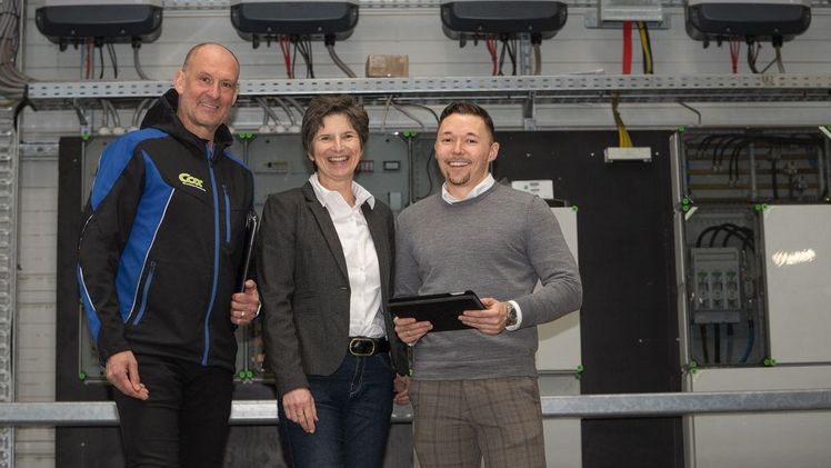 v.l. Herbert Klingenburg, Dr. Anke Schirocki  und Sebastian Gohlke vor dem Schaltschrank mit den Wechselrichtern der Photovoltaikanlage des Blumengroßhandels aus Straelen. Bild: Agrobusiness Niederrhein.