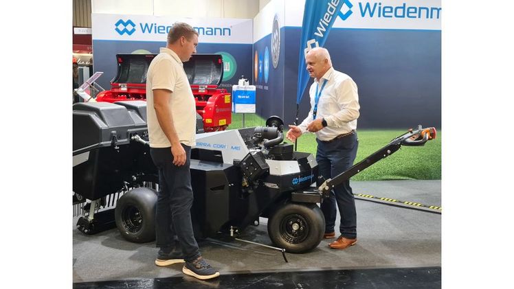 Wiedenmanns Rasenfachmann Volker Zippel, rechts, erklärt die Messeneuheit Terra Core M6: Mit ihrem ersten handgeführten Aerifizierer erweitern die Schwaben das Sortiment um eine Maschine, bei der nicht nur Präzision, Wendigkeit und Bearbeitungsqualität im Fokus stehen, sondern auch maximale Produktivität. Foto: Wiedenmann.