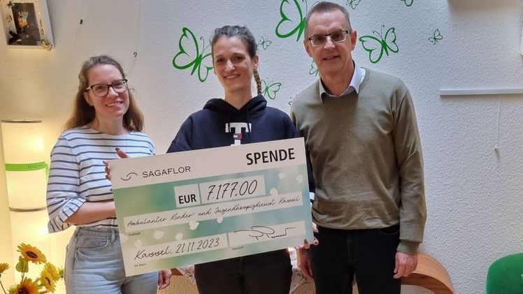 Verena Wilkat(l.) und Martin Schweikert(r.) von der SAGAFLOR AG, sowie Frau Hans (Mitte), Mutter eines betroffenen Kindes bei der Spendenübergabe. Bild: SAGAFLOR.