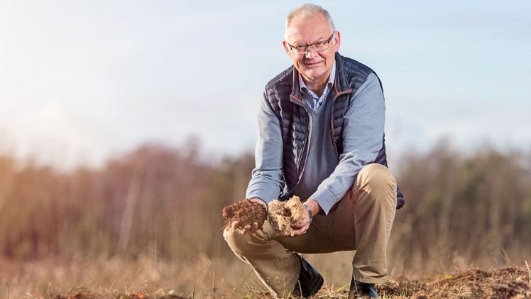Josef Gramann, geschäftsführender Gesellschafter von Gramoflor, mit den beiden Hauptrohstoffen Torf und Holzfaser in den eigenen Händen. Bild: Gramoflor.