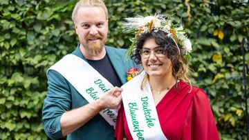 Strahlende Amtsübergabe beim Deutschen Gartenbautag. Die neue Deutsche Blumenfee Ayla Yilmaz übernimmt das Amt für 2026/27 von ihrem Vorgänger Hannes Schrader. Foto: ZVG/ Rafalzyk.