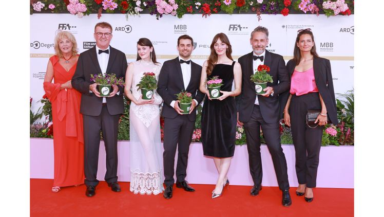 Bert Schmitz, Aufsichtsratsvorsitzender der Landgard eG (2.v.l.), überreichte gemeinsam mit Landgard-Vorstand Moritz Krannich (2.v.r.) die Blumen im Rahmen der Veranstaltung symbolisch an die Nachhaltigkeitsbotschafter*innen des Deutschen Filmpreises 2026 Lea van Acken (3.v.l.), Lucas Reiber (Mitte) und Maria Ehrich (3.v.r.). Bild: ©1000 gute Gründe/Gustav Wein.