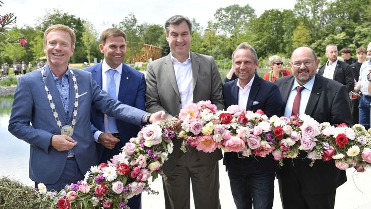 Blumen verbinden: Stephan Keck (Erster Bürgermeister Gemeinde Kirchheim), Maximilian Böltl (Altbürgermeister Gemeinde Kirchheim und Initiator der Landesgartenschau), Bayerns Ministerpräsident Dr. Markus Söder, Bayerns Umweltminister Thorsten Glauber und der Vorsitzender der ByLGS, Gerhard Zäh, haben ganz im Sinne des Mottos „Zusammen.wachsen.“ eine Blumenkette zusammengefügt. Foto: ByLGS/Marcus Schlaf.