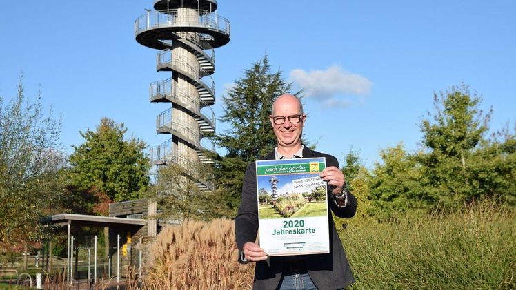 Park-Geschäftsführer Christian Wandscher präsentiert das Plakat zur Jahreskarte 2020. Bild: Park der Gärten.
