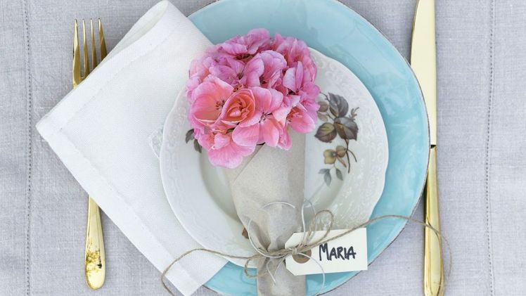 Ein Blumengruß für jeden Gast. Ein mit Packpapier umwickeltes, mit Namensschild versehenes Geraniensträußchen ist eine originelle Alternative für die übliche Tischkarte und schnell und einfach umgesetzt. Tipp: In einem mit Wasser gefüllten Orchideenröhrchen mit Gummideckel bleiben die Geranien länger strahlend schön. Bild: Pelargonium for Europe.