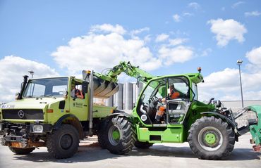 Multifarmer lädt Schüttgut in Boxen und auf Unimogs oder Lkws.