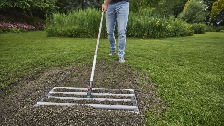 Der neue Gartenhelfer GARDENA combisystem-Rasenrakel unterstützt beim Ausbringen von Erde und Sand auf großen Flächen und ermöglicht ein gleichmäßiges Verteilen. Bild: © GARDENA.