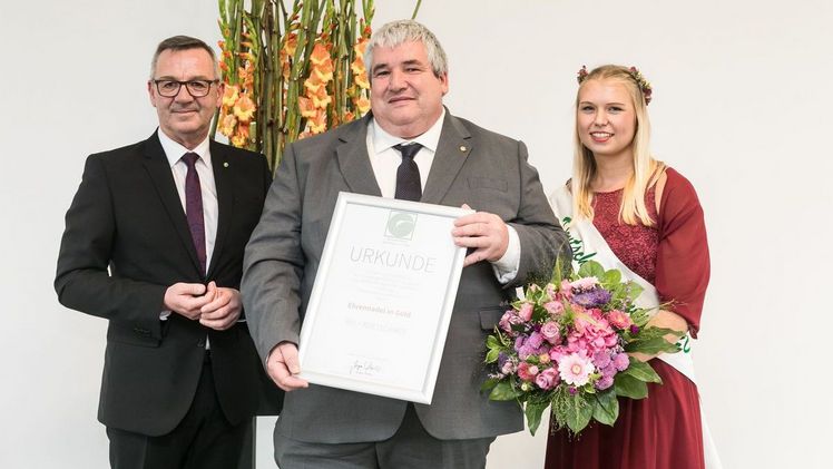 Im Rahmen des Deutschen Gartenbautags verlieh ZVG-Präsident Mertz Ralf Kretschmer die Ehrennadel in Gold für sein außerordentliches Engagement als Vorsitzender im Ausschuss für Bildungspolitik und Berufsbildung. (v.l.n.r. Jürgen Mertz, Ralf Kretschmer, Deutsche Blumenfee Lisa Bartels). Foto: ZVG/ Thomas Rafalzyk.