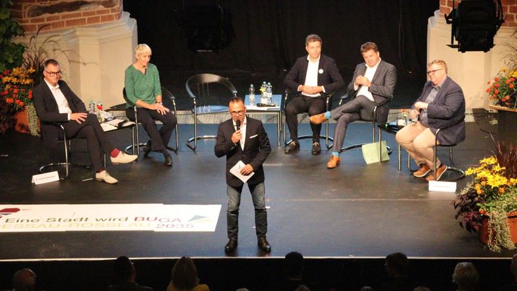 DBG-Geschäftsführer Dr. Achim Schloemer (v.l.), Bürgermeisterin Jacqueline Lohde, Oberbürgermeister Dr. Robert Reck, Minister Sven Schulze und BUGA-Beauftragter Alexander Hilge. Moderator Thomas Passek. Bild: © Stadt Dessau-Roßlau.