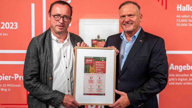 REWE Group Vorstand Peter Maly übergibt das letzte Exemplar des Papier-Prospekts an NABU-Bundesgeschäftsführer Leif Miller. Bild: REWE.