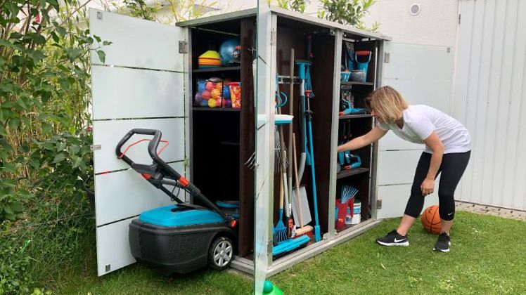 Modell Teras - Frau holt Gartenutensilien aus dem Schrank. Bild: Garten-Q.