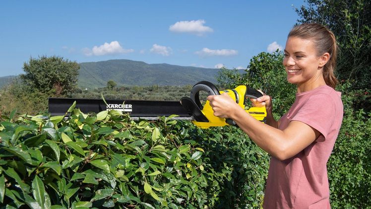 Kein Kabel stört die Bewegungsfreiheit bei einer Akku-Heckenschere. Ist das Modell mit einem Schnittgutkehrer auf dem Messer ausgestattet, werden die abgetrennten Äste und Zweige mit der Bewegung des Messers direkt abgekehrt und auf den Boden befördert. Bild: Kärcher.