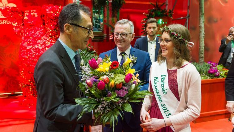 Bundeslandwirtschaftsminister Cem Özdemir wird von ZVG-Präsidenten Jürgen Mertz und der Deutschen Blumenfee 2023/24 Kathrin Köhler begrüßt. Bild: ZVG/ Rafalzyk.