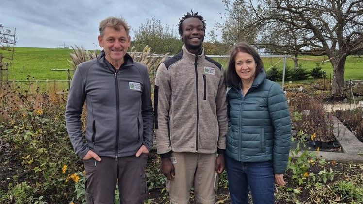 Hubert Fischer (links) und Lilli Fischer, beide Geschäftsführer der Hubert Fischer Garten- und Landschaftsbau GmbH, zusammen mit Lawrence Aongo. Bild: Carlotta Stadler, Hubert Fischer Garten- und Landschaftsbau GmbH.